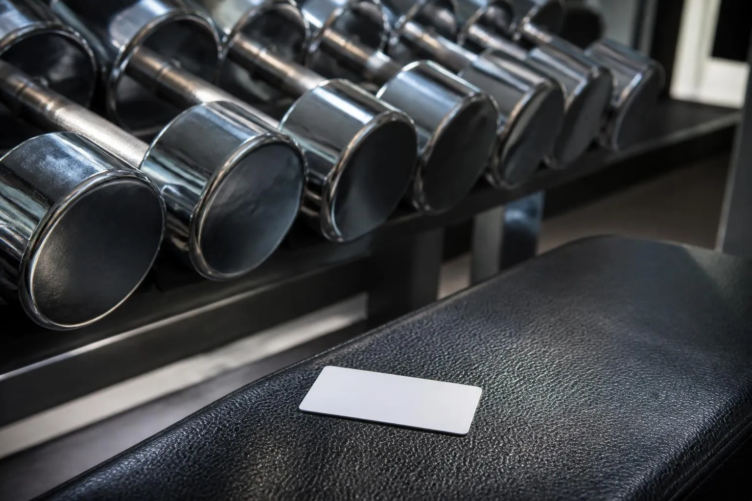 Un rack d'haltères et une carte d'accès posée sur le banc de musculation