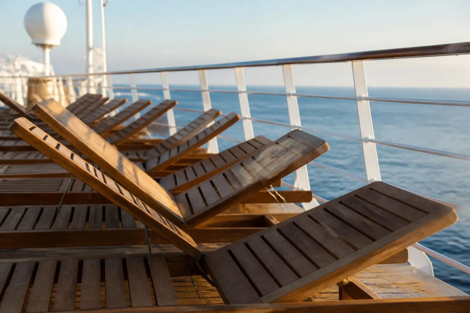 Le pont supérieur d’un navire de croisière et ses transats alignés face à la mer