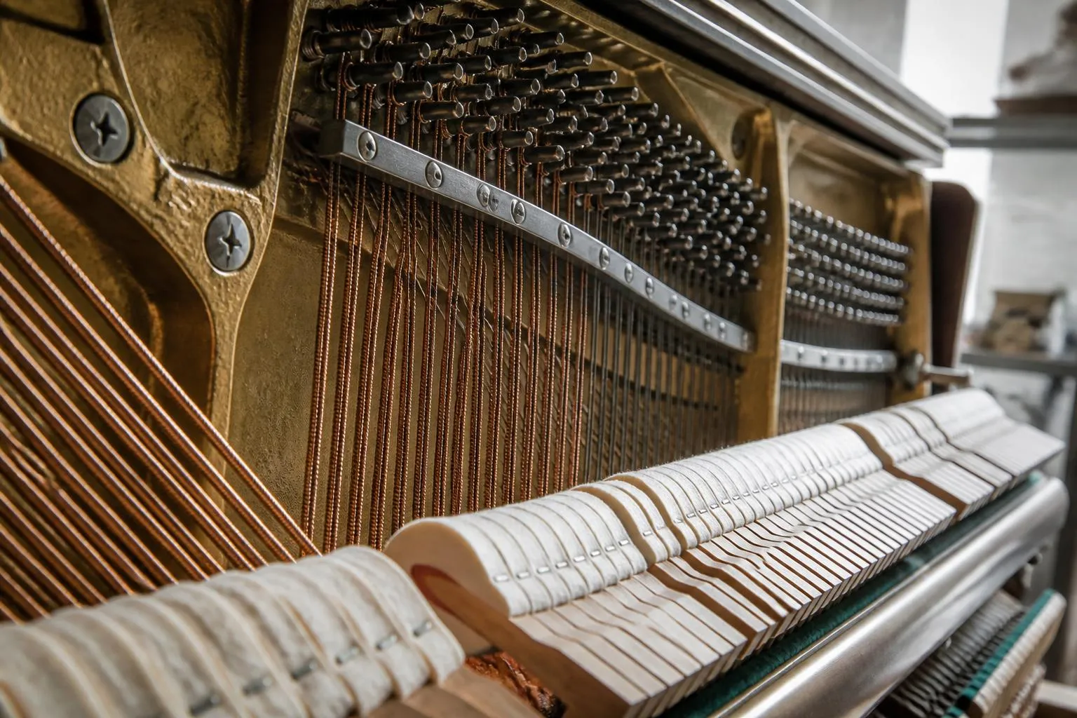 La mécanique découverte d'un piano droit, marteaux et cordes visibles